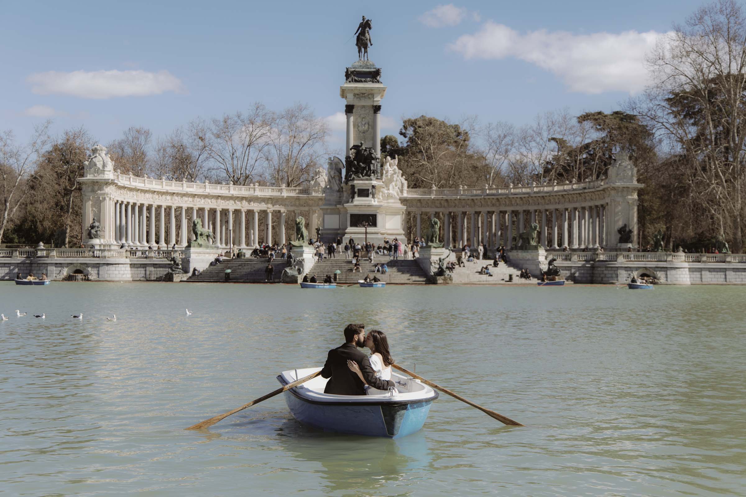 madrid-couple-photoshoot Couple kissing on the boats at El Retiro Park lake in Madrid during their engagement session